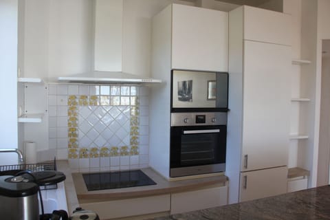 kitchen with stove top, microwave oven, oven, and refrigerator