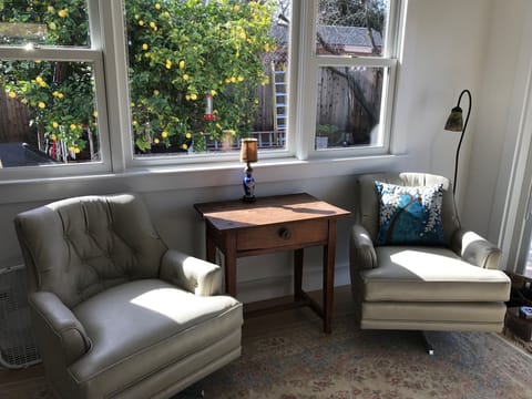 Sunny seating area in master bedroom looking out at  prolific lemon tree.