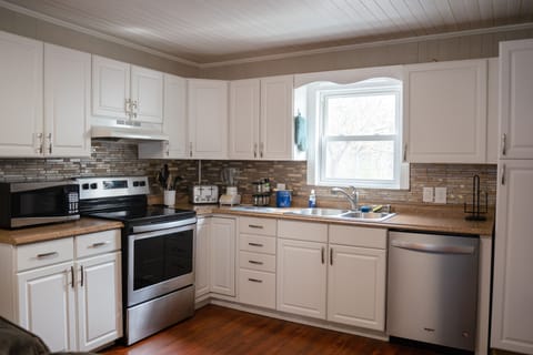 Updated kitchen with stainless steel appliances, cookware, and dining ware