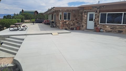 Large concrete parking area in front of the house.