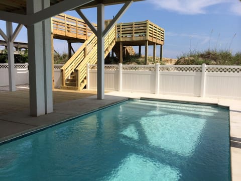 Pool area with decking and stairs to main floor.