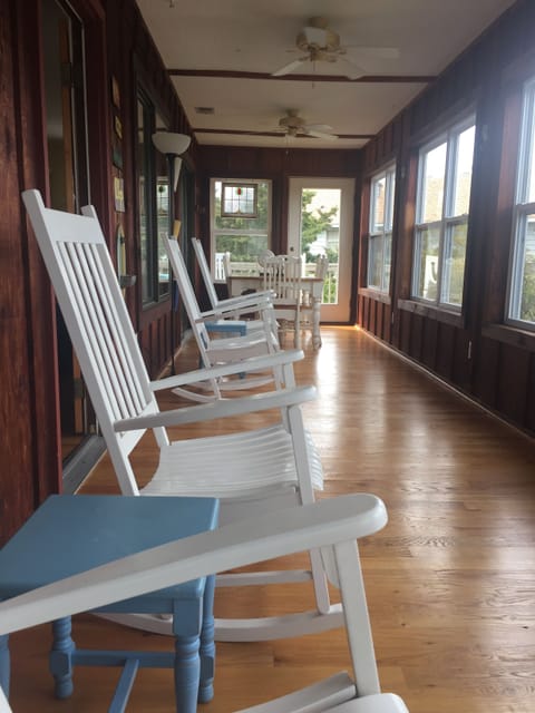 sun room has 4 rocking chairs and 2 side tables