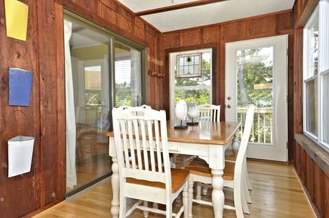 Dining area in sun room, door to "coffee deck" with high top table & 2 chairs.