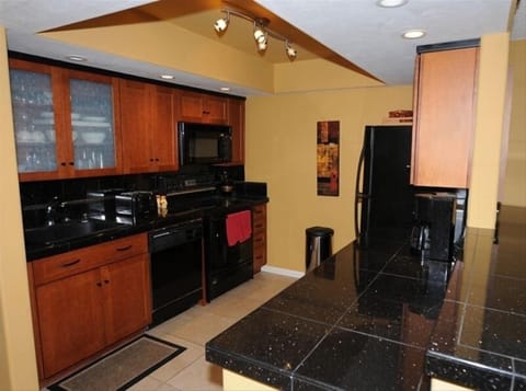 Well stocked modern kitchen with granite countertops