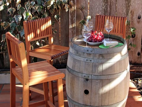 Enjoy a glass of wine at the wine barrel bar under shaded arbor.