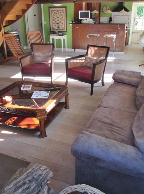 Living area with open kitchen and bar stands in the background