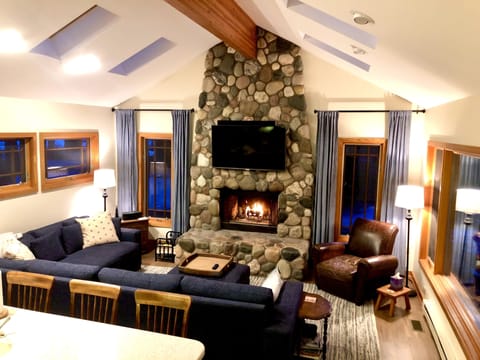 Comfortable Living Space with Stone Fireplace and Vaulted Ceiling
