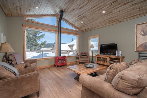 Bright, sunny living room with views of the mountains, a gas stove and a 55" TV.