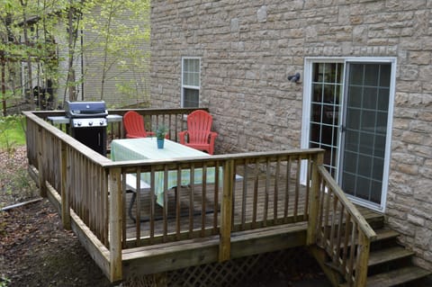 Backyard deck with gas grill and picnic table.