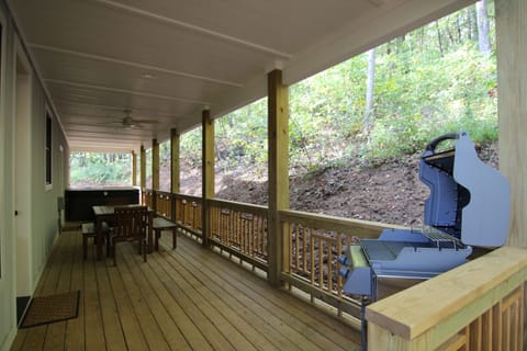 Back porch with gas grill, dining table, and hot tub.