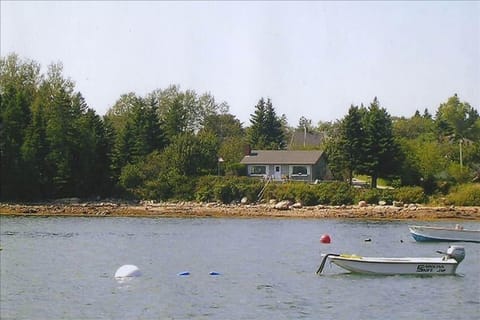 46 School St. from the water showing house, decks, woods, lawn, shoreline, steps