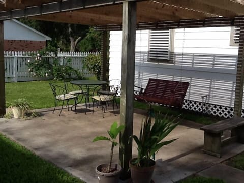 Lattice covered patio area with table and seating for 4