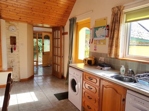 Horseshoe kitchen with door to hallway and door on right to private patio