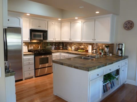 Beautiful kitchen features slate counters and backsplash, stainless appliance