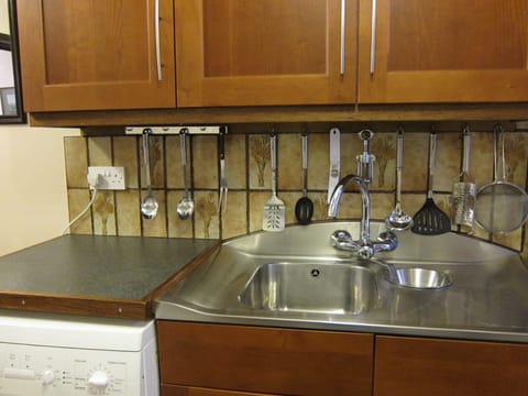 Stainless steel sink with mixer tap. Washer under adjoining work top