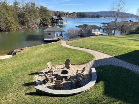 View of outdoor fire pit and dock from upper veranda.