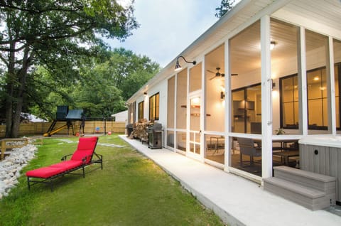 Lake side of property : screened porch, hot tub, playground, fire pit, yard.