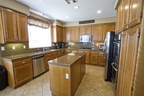 Large, fully stocked kitchen with island, stainless appliances & coffee maker