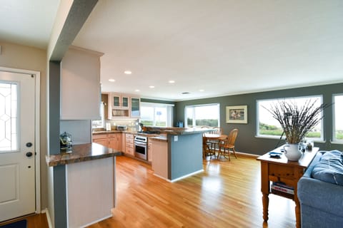 Wall to Wall windows line the living room area offering panoramic ocean views