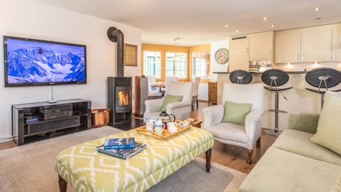 Living room has a 55" home cinema system and a wood-burning stove