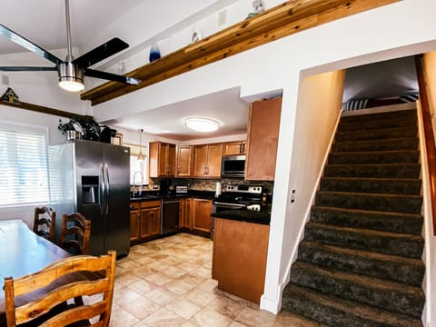 Kitchen with stainless appliances & long, log top dining table.