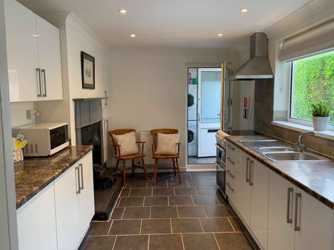 Kitchen leading to utility room, downstairs w.c and door to back garden