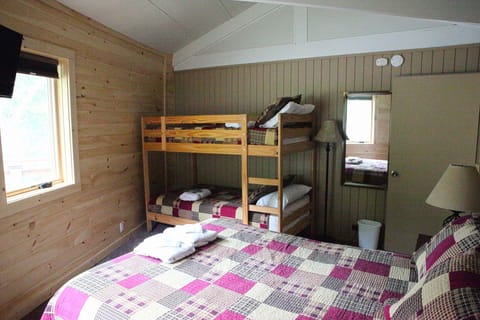 Upstairs guest bedroom with queen bed and twin bunks
