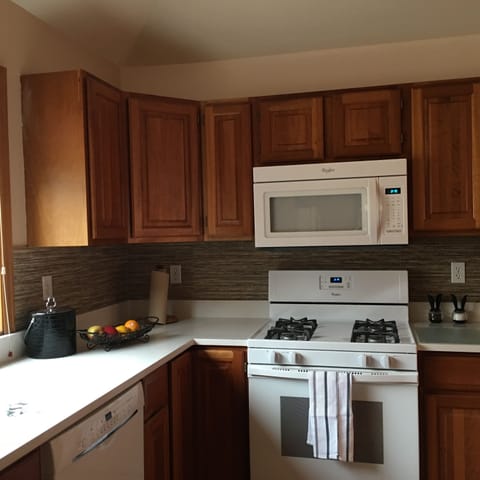 Cherry cabinets, quartz countertops, gas range in fully stocked kitchen