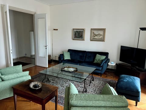 Large living room with couch, easy chairs, ottoman, and smart tv