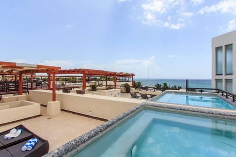 An incredible private roof terrace w/pool, loungers, shaded sofa areas, & ocean view!