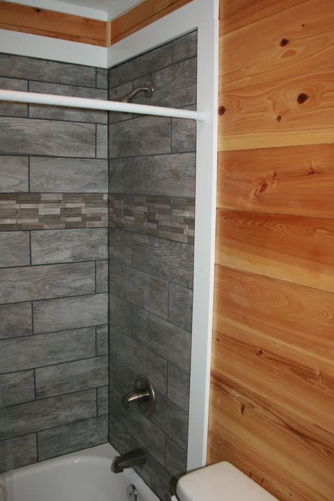 Custom tile in both bathrooms with cypress walls and modern sinks