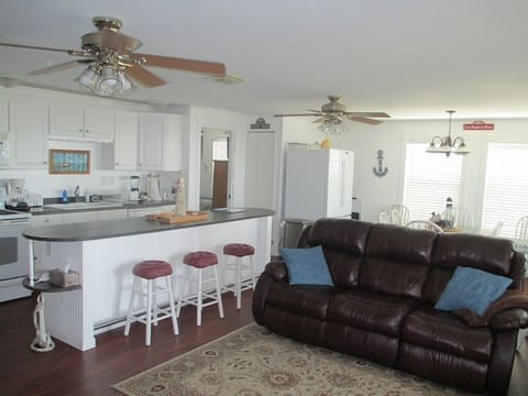 Great room has a reclining couch, sofa, reclining loveseat, table & 4 chairs.