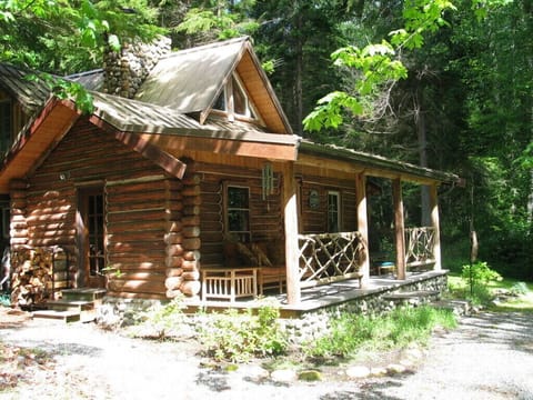 Charming cabin with covered front porch sitting area.