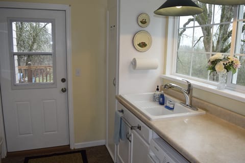 Utility room opens onto back deck near the BBQ.