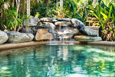 rejuvenating pool  in natural setting has a water fall