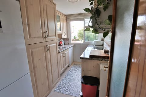Kitchen with washing machine, dishwasher, microwave, oven, induction hob.