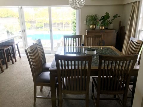 dining area opening into kitchen and onto pool area