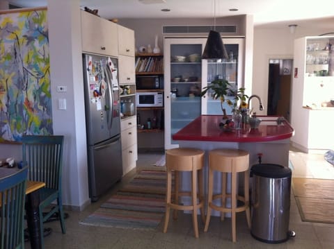 Open kitchen with a red marble island with 2 large sinks.