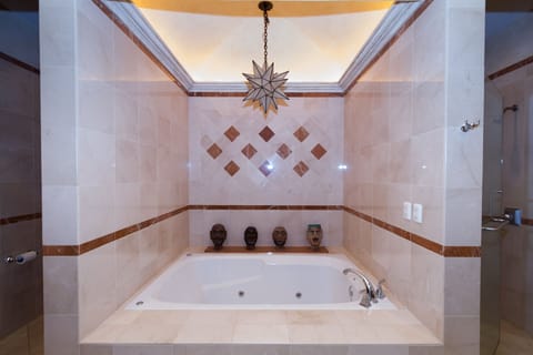 All polished marble bathroom with a large two person jacuzzi tub and shower.