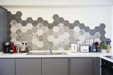 Kitchen with washer-dryer, fridge freezer, oven and hob and 2 coffee machines