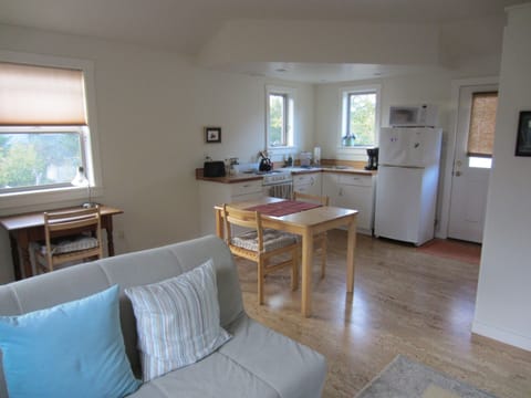 Part of living area and kitchen, which includes microwave, stove/oven, toaster.