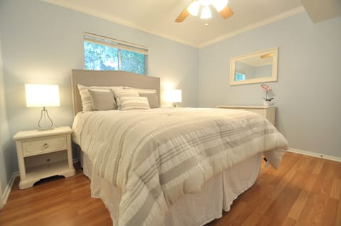 Cozy Bedroom features a Queen Bed w Designer headboard and natural Light.