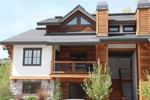 View from parking space showing large deck off dining area and stairwell to unit