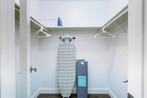 Master walk-in closet. The house includes a Pack 'n Play, a vacuum, and an iron with an ironing board for your convenience.