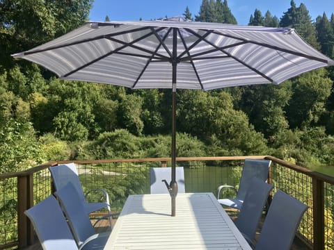 Deck overlooking the river with propane BBQ and seating for 8