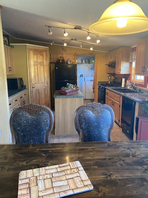 Kitchen with laundry room and back porch area. Kitchen has full frig