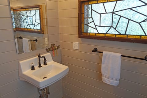  The stained glass window and accent lighting make the bathroom airy and bright.