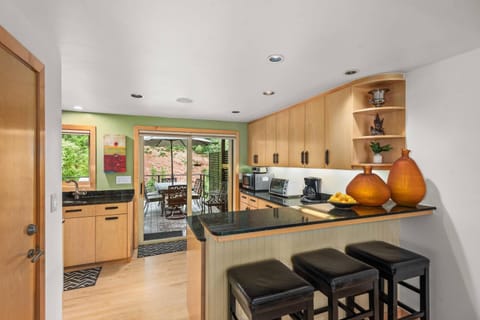 A dining table for 8 indoors, another outdoors and a breakfast bar for 3 create many spots to dine or have a hot cup of coffee.