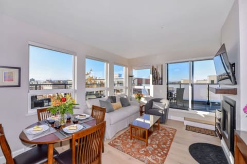 Main Living & Dining with seating for 4. Dedicated work space with a desk and office lamp, gas fireplace and large windows surrounding for a bright and spacious living space! 