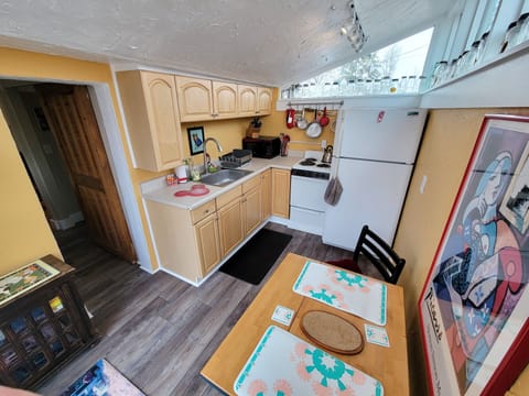 Kitchen has stove, fridge, microwave, coffeemaker, toaster, pots/pans, dishes.